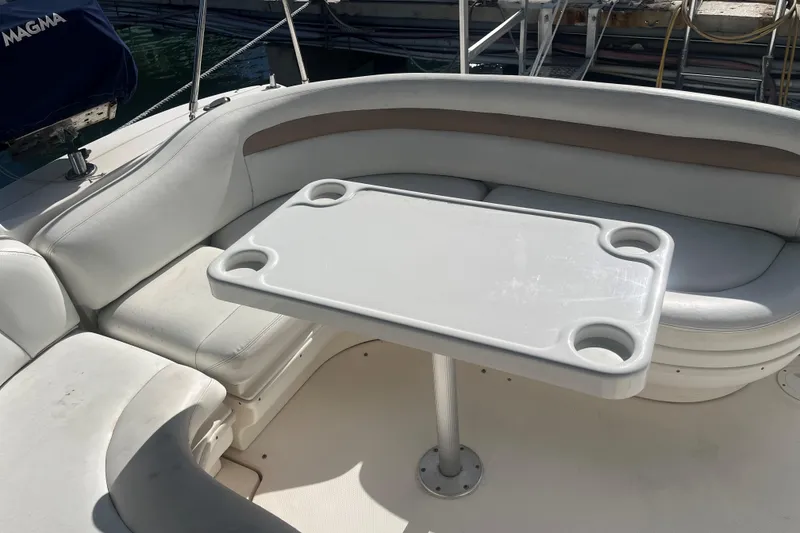 Slide: The Image of 2004 Sea Ray 340 Sundancer boat interior with white seating and table. - 9