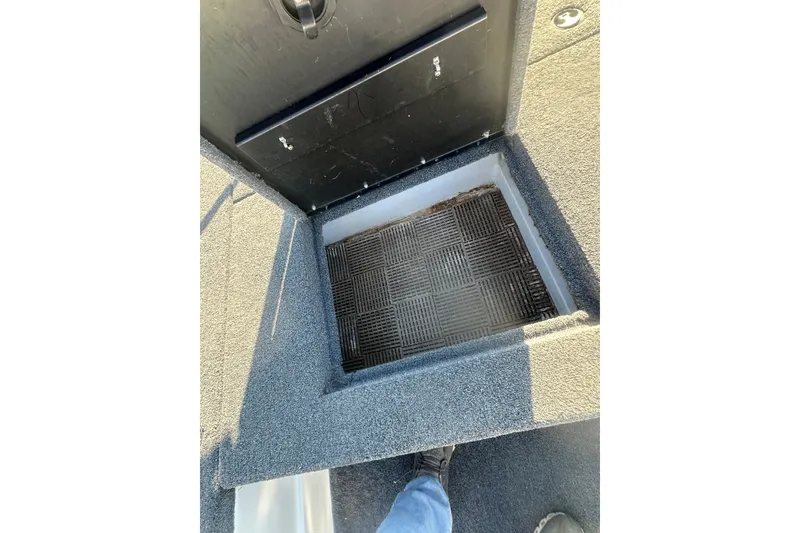 Slide: The Image of 2004 Bumble Bee Pro Vee XT boat storage compartment with textured flooring. - 28