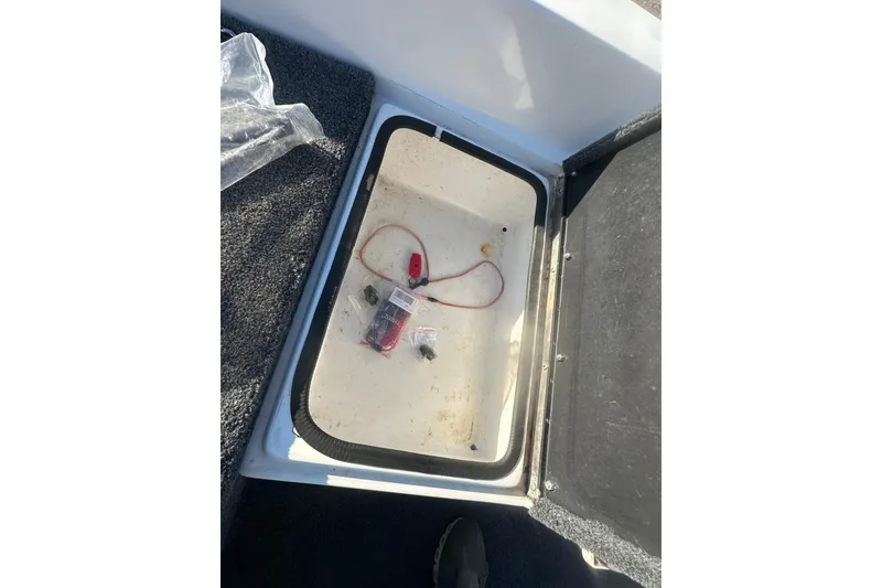 Slide: The Image of Open storage compartment in 2004 Bumble Bee Pro Vee XT boat with items inside. - 29