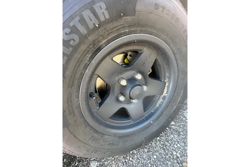 Slide: The Image of Close-up of a 2004 Bumble Bee Pro Vee XT wheel and tire on asphalt. - 34