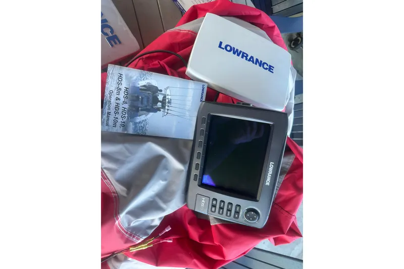 Slide: The Image of Lowrance fishfinder with manual on red fabric, Bumble Bee Pro Vee XT 2004. - 39