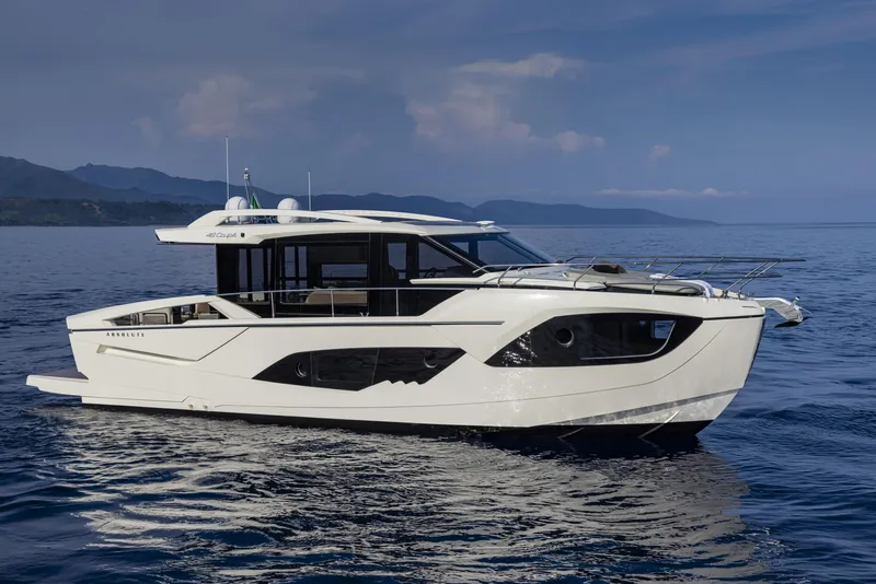 Slide: The Image of 2024 Absolute 48 Coupe luxury yacht cruising on calm waters. - 2