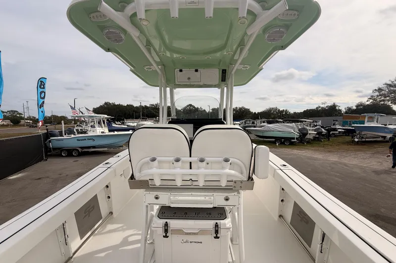 Slide: The Image of 2023 Sea Pro 239 Center Console boat interior at a dealership, showcasing seating and console features. - 15