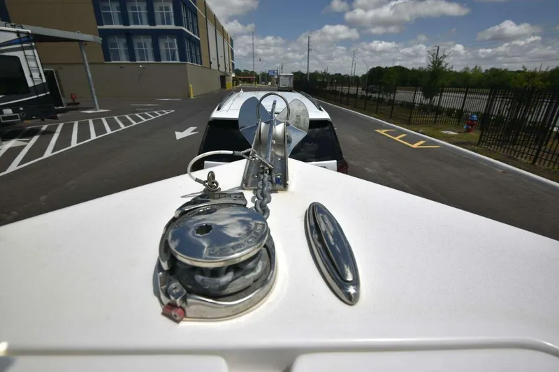 Slide: The Image of 2023 Sea Pro 239 Center Console boat interior with white seating, docked among other boats. - 41