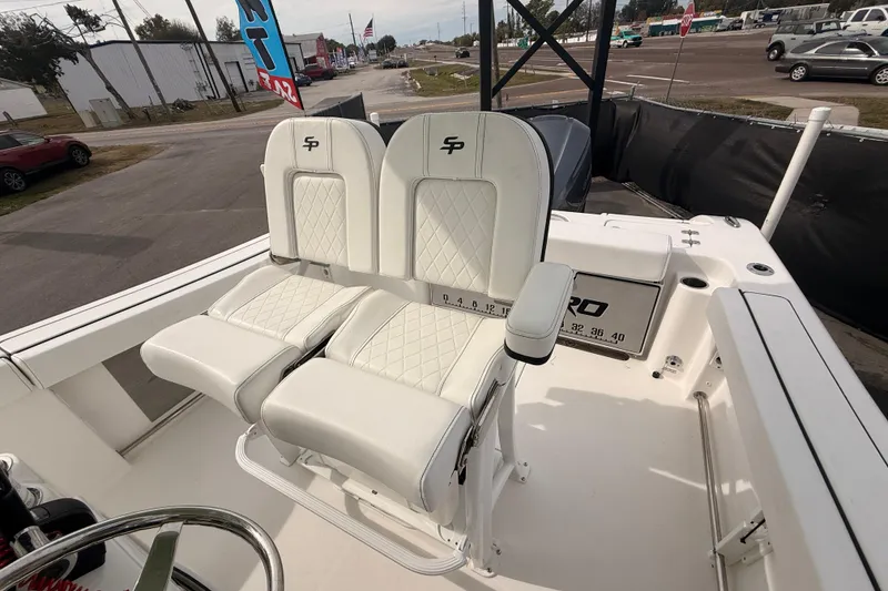 Slide: The Image of 2023 Sea Pro 239 Center Console boat with white cushioned seating and steering wheel. - 59