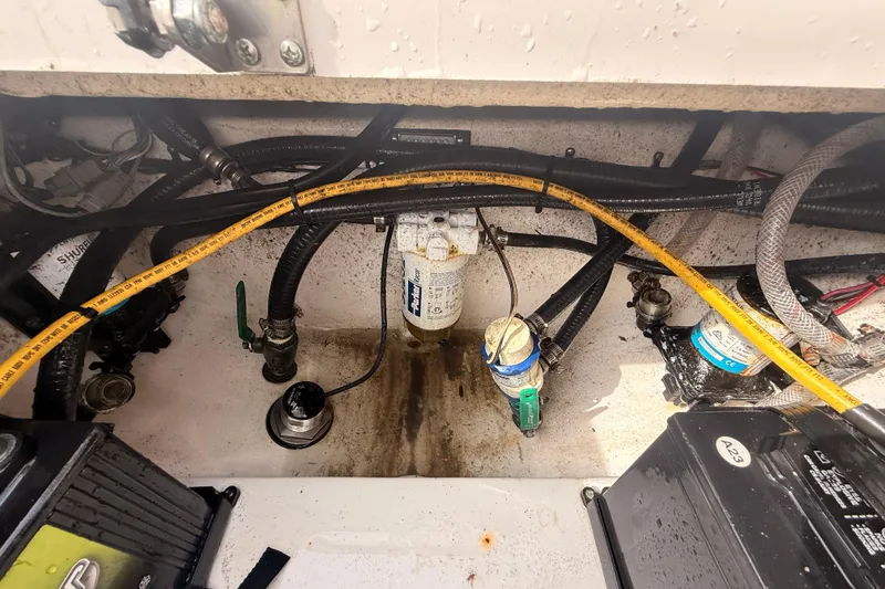 Slide: The Image of 2023 Sea Pro 239 Center Console engine compartment with hoses and filters. - 81