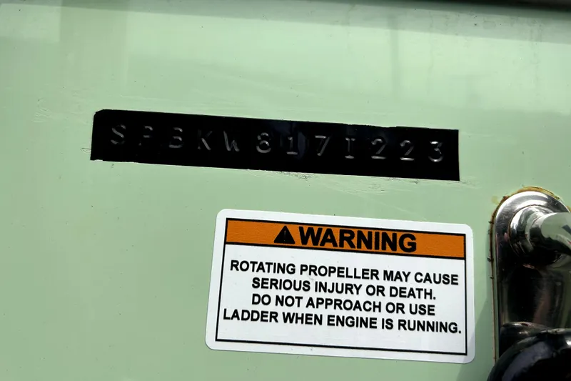 Slide: The Image of 2023 Sea Pro 239 Center Console with warning label about rotating propeller safety. - 82