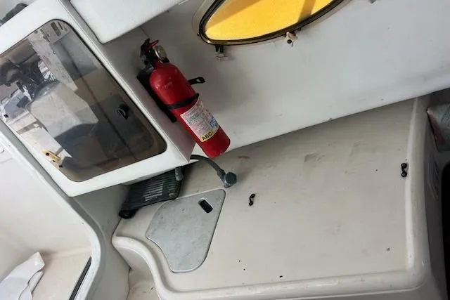 Slide: The Image of 1998 Pro-Line 2610 Walkaround cabin interior with fire extinguisher and storage area. - 10