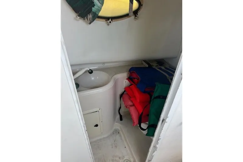 Slide: The Image of 1998 Pro-Line 2610 Walkaround cabin interior with sink and life jackets. - 12