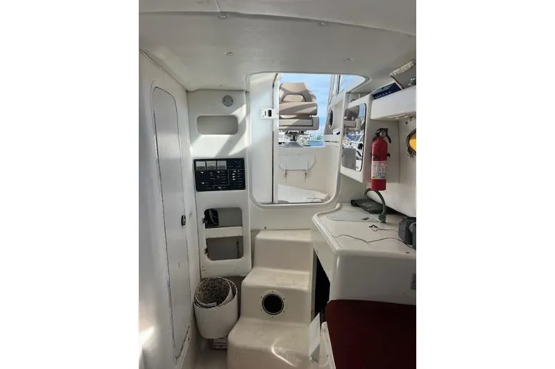 Slide: The Image of Interior of 1998 Pro-Line 2610 Walkaround boat, featuring control panel and fire extinguisher. - 13