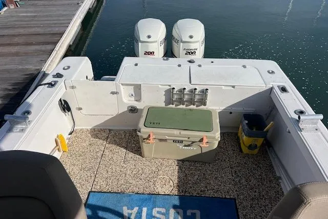 Slide: The Image of 1998 Pro-Line 2610 Walkaround boat deck with twin 200 HP engines and fishing gear. - 14