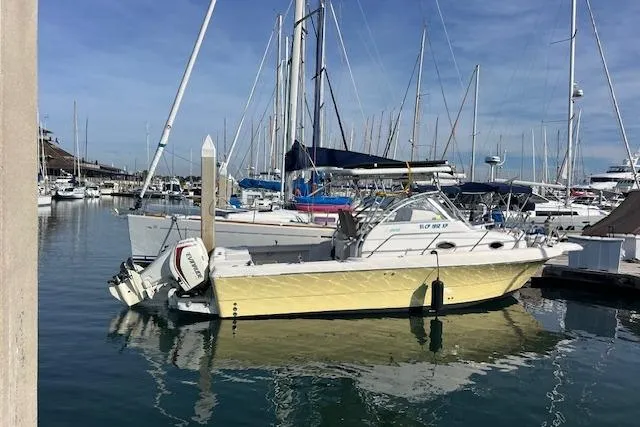 Slide: The Image of 1998 Pro-Line 2610 Walkaround boat docked in a marina with sailboats. - 17
