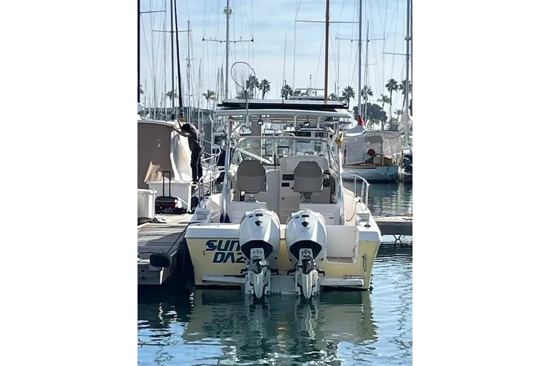 Slide: The Image of 1998 Pro-Line 2610 Walkaround boat docked with twin outboard motors. - 19