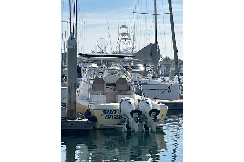 Slide: The Image of 1998 Pro-Line 2610 Walkaround boat docked in marina with twin outboard engines. - 20