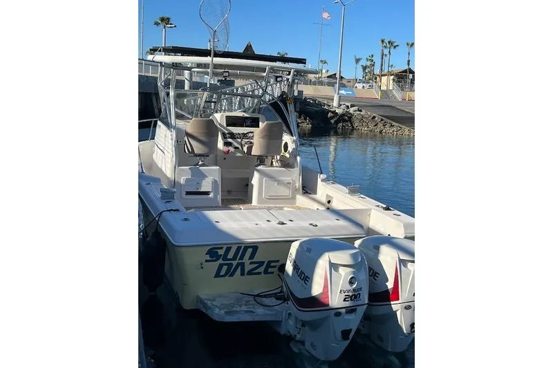 Slide: The Image of 1998 Pro-Line 2610 Walkaround boat with dual Evinrude engines, docked at marina. - 23