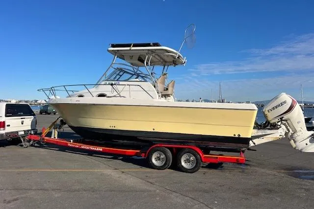 Slide: The Image of 1998 Pro-Line 2610 Walkaround boat on trailer, parked near waterfront. - 25