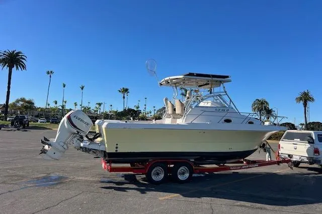 Slide: The Image of 1998 Pro-Line 2610 Walkaround boat on trailer, parked in sunny lot with palm trees. - 28