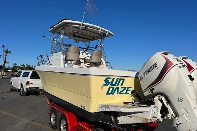 Slide: The Image of 1998 Pro-Line 2610 Walkaround boat on trailer, featuring "Sun Daze" and Evinrude engine. - 32