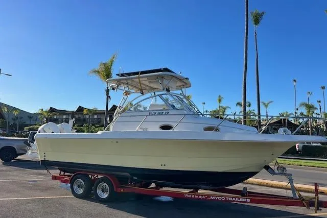 Slide: The Image of 1998 Pro-Line 2610 Walkaround boat on trailer, parked outdoors under clear blue sky. - 36