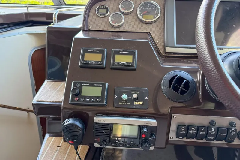 Slide: The Image of 2015 Regal 38 Express boat helm with steering wheel and control panel. - 52