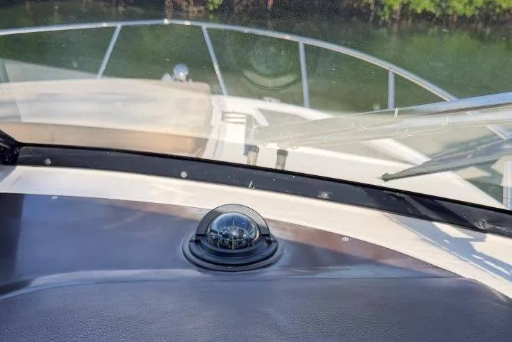 Slide: The Image of Cockpit of 2015 Regal 38 Express boat with steering wheel and control panel. - 55