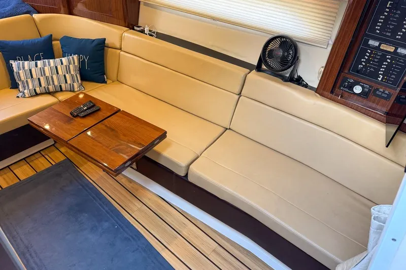 Slide: The Image of Interior of a 2015 Regal 38 Express boat with beige seating and carpeted floor. - 76