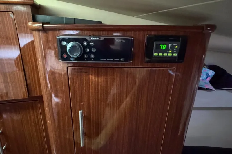 Slide: The Image of 2015 Regal 38 Express yacht kitchen with microwave, sink, and wooden cabinets. - 98
