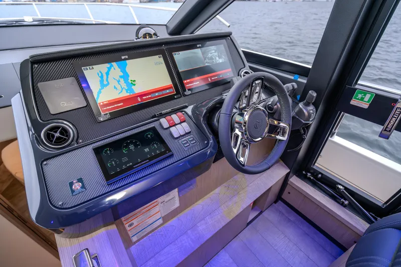 Slide: The Image of Helm of 2026 Absolute 48 Coupe yacht with advanced navigation displays and steering wheel. - 25