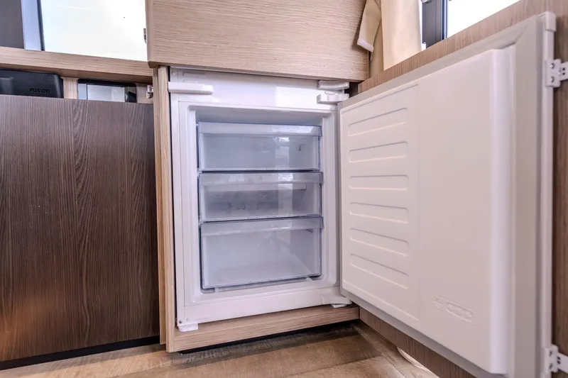 Slide: The Image of Open fridge in Absolute 48 Coupe yacht, 2026 model, with three transparent drawers. - 37