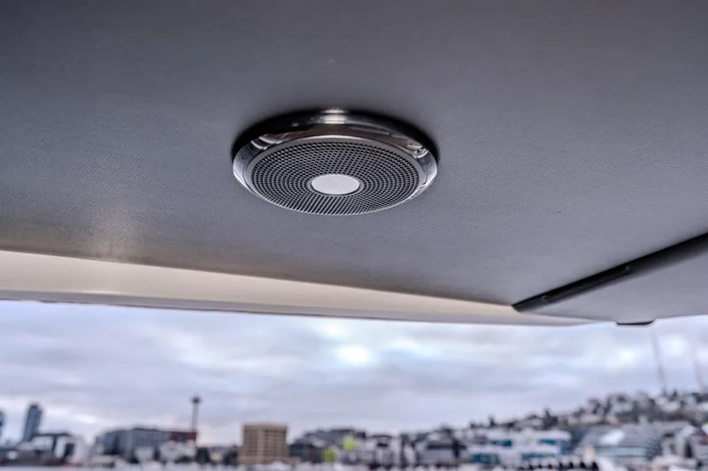 Slide: The Image of Ceiling speaker inside 2026 Absolute 48 Coupe yacht, with cityscape in the background. - 47