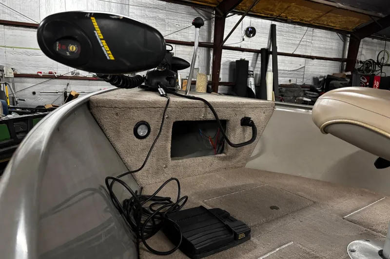 Slide: The Image of 2003 Lund 1650 Explorer SS boat dashboard with steering wheel and gauges in a garage setting. - 19