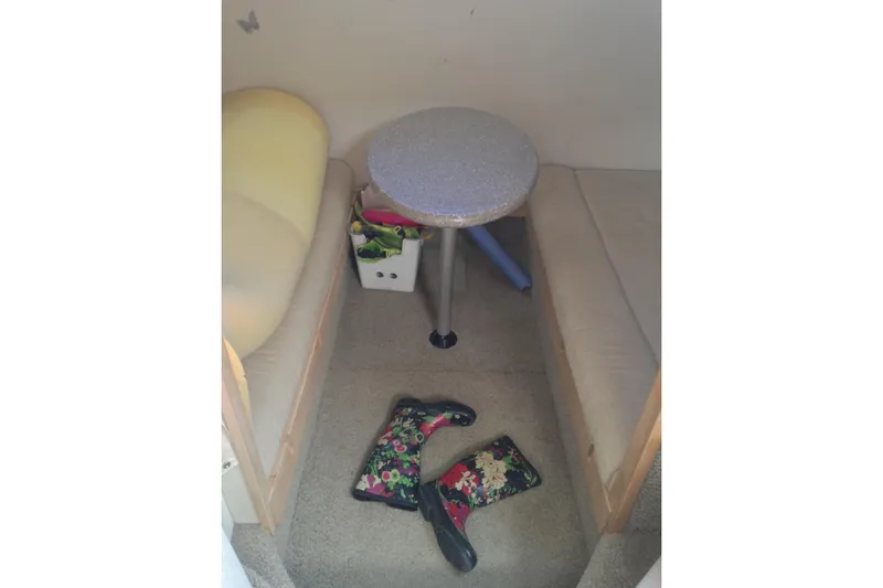 Slide: The Image of Interior of 2000 Maxum 3300 SCR boat with table, seating, and floral boots. - 14