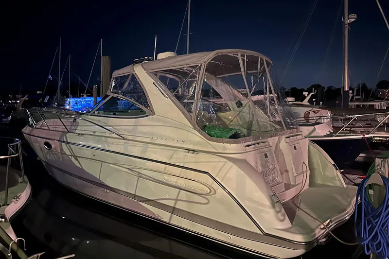 Slide: The Image of 2000 Maxum 3300 SCR boat docked at night, featuring sleek design and covered cockpit. - 15
