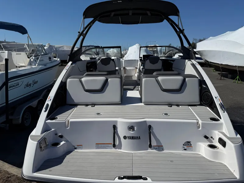 Slide: The Image of 2023 Yamaha Boats AR250, sleek design, spacious seating, modern features, docked outdoors. - 15