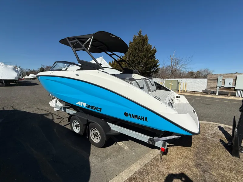 Slide: The Image of 2023 Yamaha Boats AR250 on trailer, blue and white design, parked outdoors. - 7