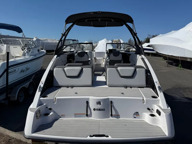 Slide: The Image of 2023 Yamaha Boats AR250, rear view, docked, showcasing spacious seating and sleek design. - 8