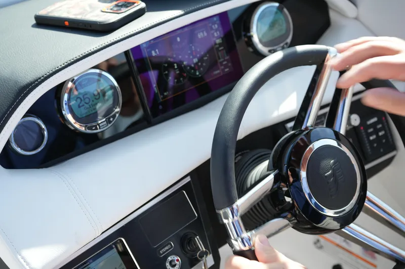 Slide: The Image of Steering wheel and dashboard of 2026 Four Winns HD3 OB boat, featuring modern controls. - 14