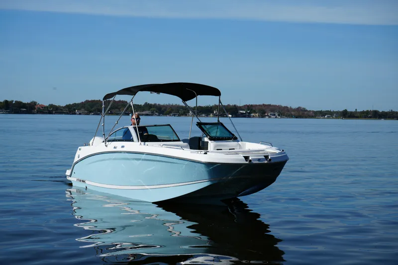 Slide: The Image of 2026 Four Winns HD3 OB boat cruising on a calm lake under clear skies. - 25