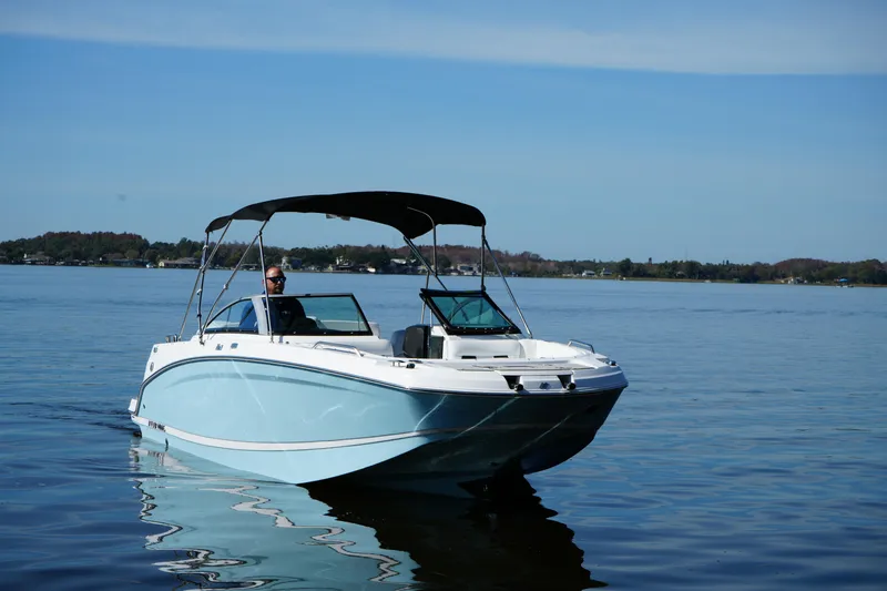 Slide: The Image of 2026 Four Winns HD3 OB boat cruising on a calm lake under a clear sky. - 26