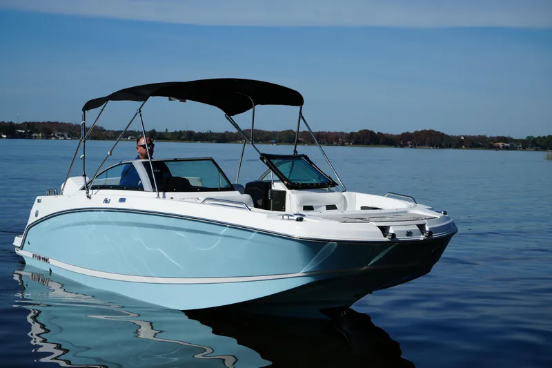 Slide: The Image of 2026 Four Winns HD3 OB boat on a calm lake under clear skies. - 28