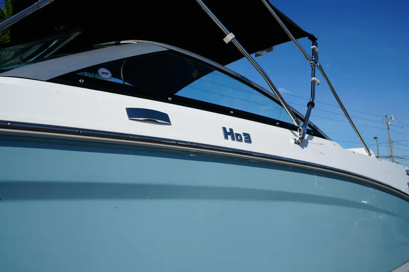 Slide: The Image of 2026 Four Winns HD3 OB boat with sleek design and blue hull under clear sky. - 3
