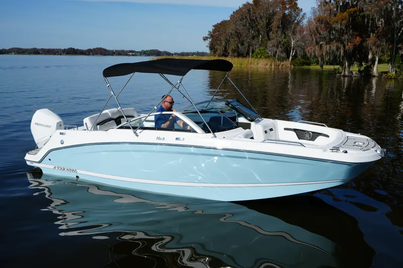 Slide: The Image of 2026 Four Winns HD3 OB boat on a serene lake with lush trees in the background. - 32