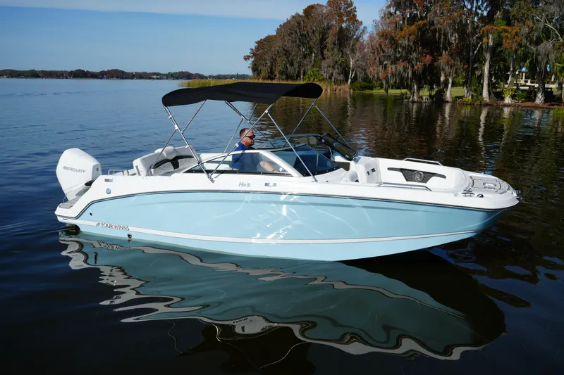 Slide: The Image of 2026 Four Winns HD3 OB boat on calm lake with trees in background. - 33