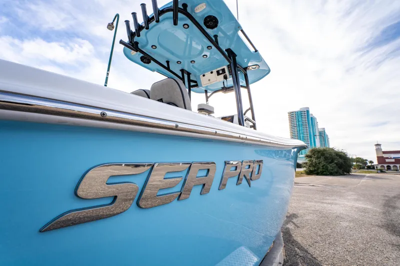 Slide: The Image of 2021 Sea Pro 219 Center Console boat with blue hull, cityscape background. - 12