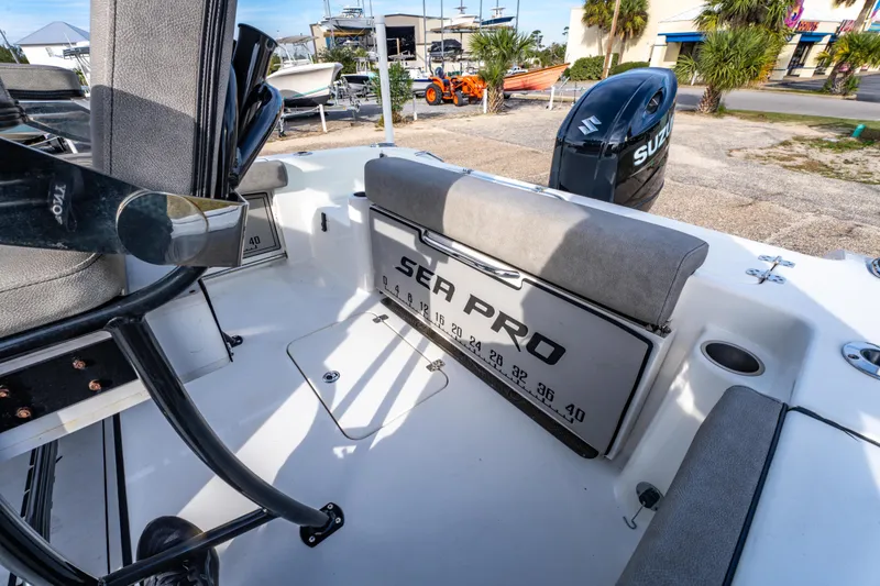 Slide: The Image of 2021 Sea Pro 219 Center Console boat interior with Suzuki engine, docked outdoors. - 14