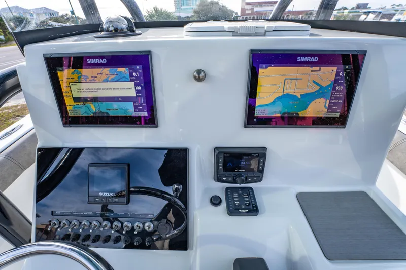 Slide: The Image of 2021 Sea Pro 219 Center Console dashboard with dual Simrad displays and Suzuki controls. - 20