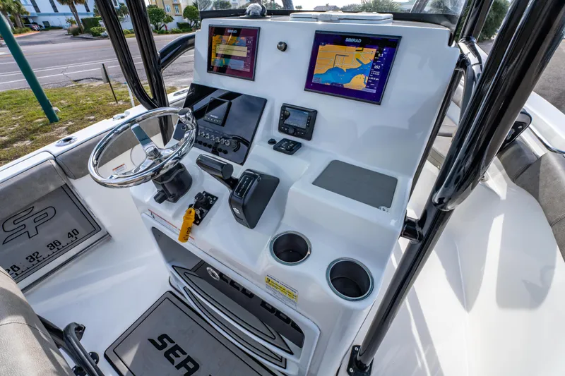 Slide: The Image of 2021 Sea Pro 219 Center Console boat dashboard with navigation screens and controls. - 21