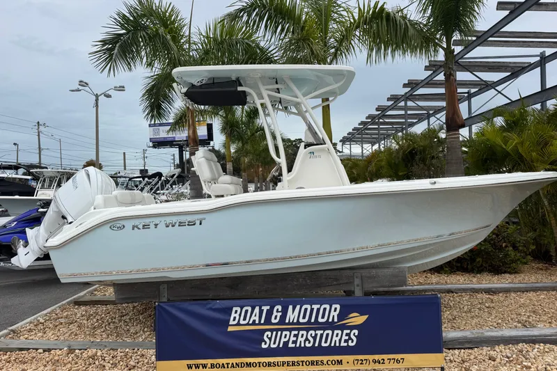 The Image of 2026 Key West 219 FS boat displayed at Boat & Motor Superstores, surrounded by palm trees. - 1