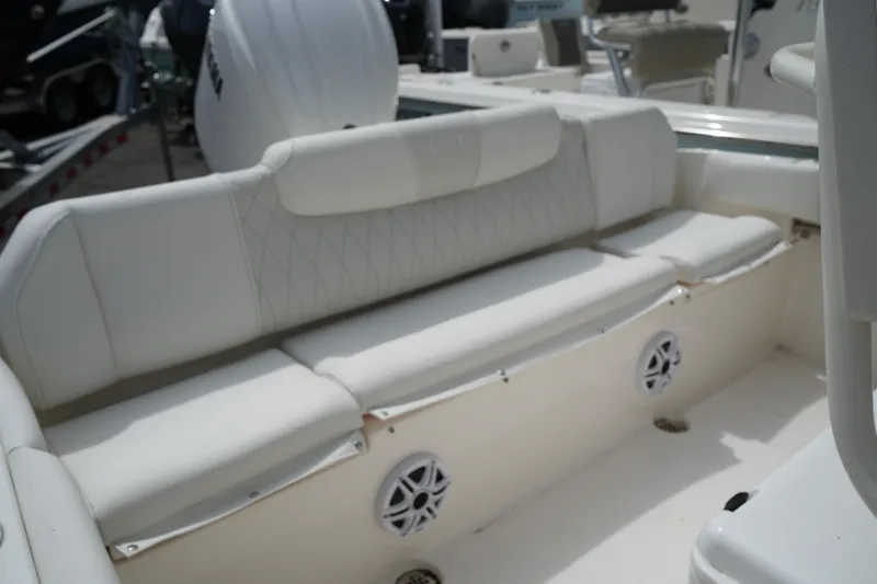 Slide: The Image of 2026 Key West 219 FS boat interior with white cushioned seating and built-in speakers. - 44