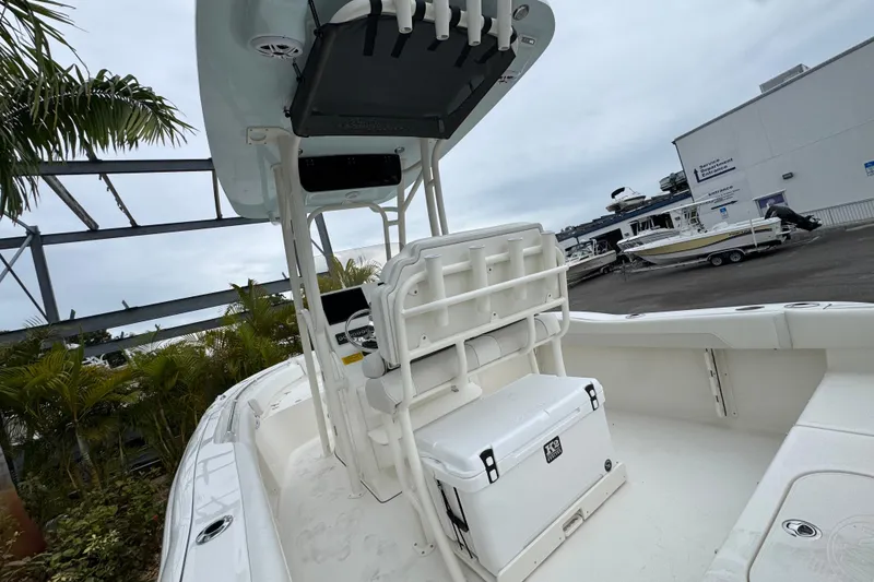 Slide: The Image of 2026 Key West 219 FS boat interior with seating and cooler, docked near palm trees. - 6